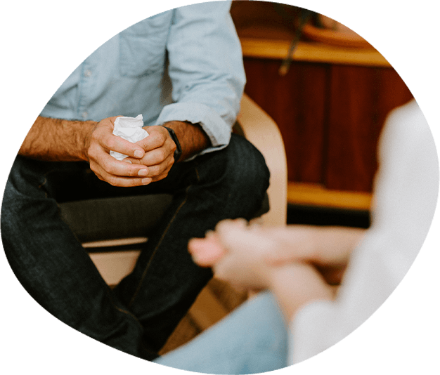 A man holds tissues in his hands while in therapy
