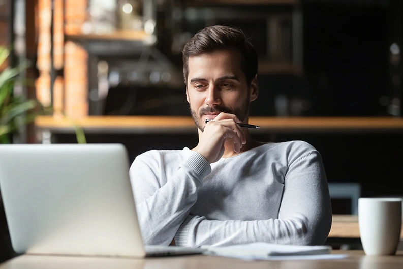 man looking at laptop and thinking