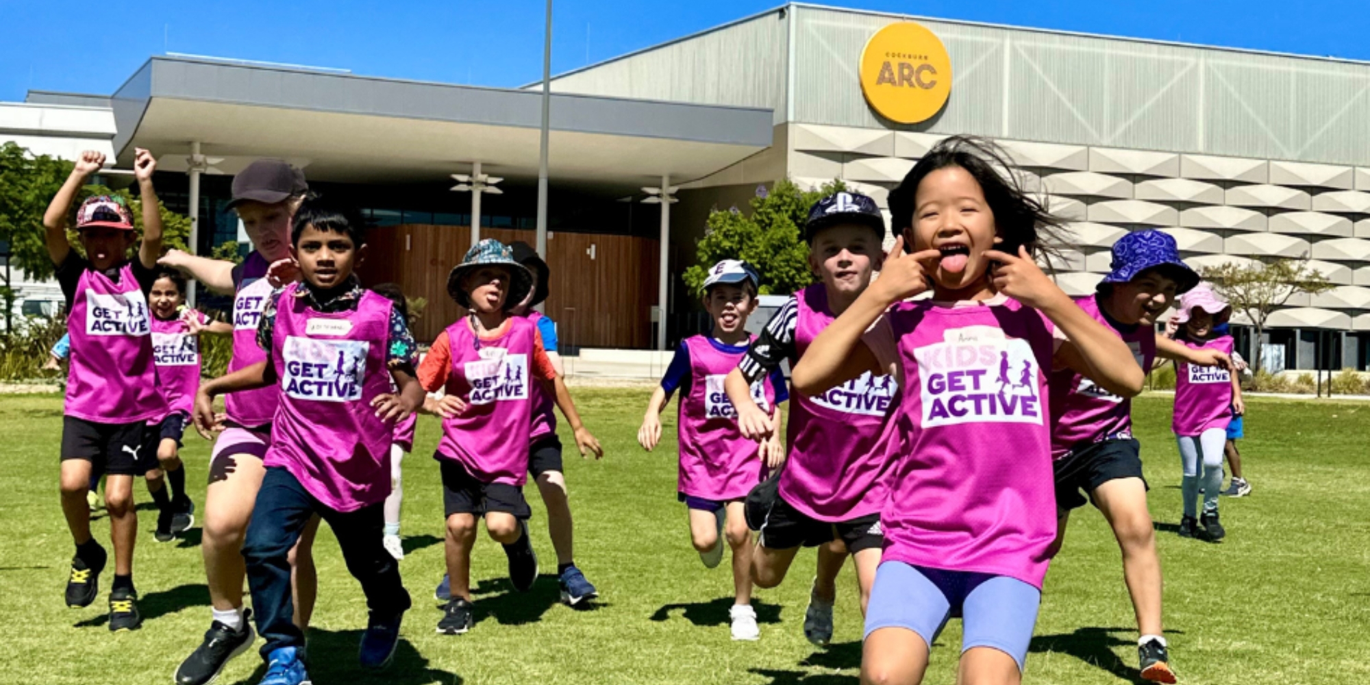Kids Get Active Program at Cockburn ARC with the City of Cockburn banner. The banner conists of an image of children running outside towards the camera wearing a 'Kids Get Active' jersey