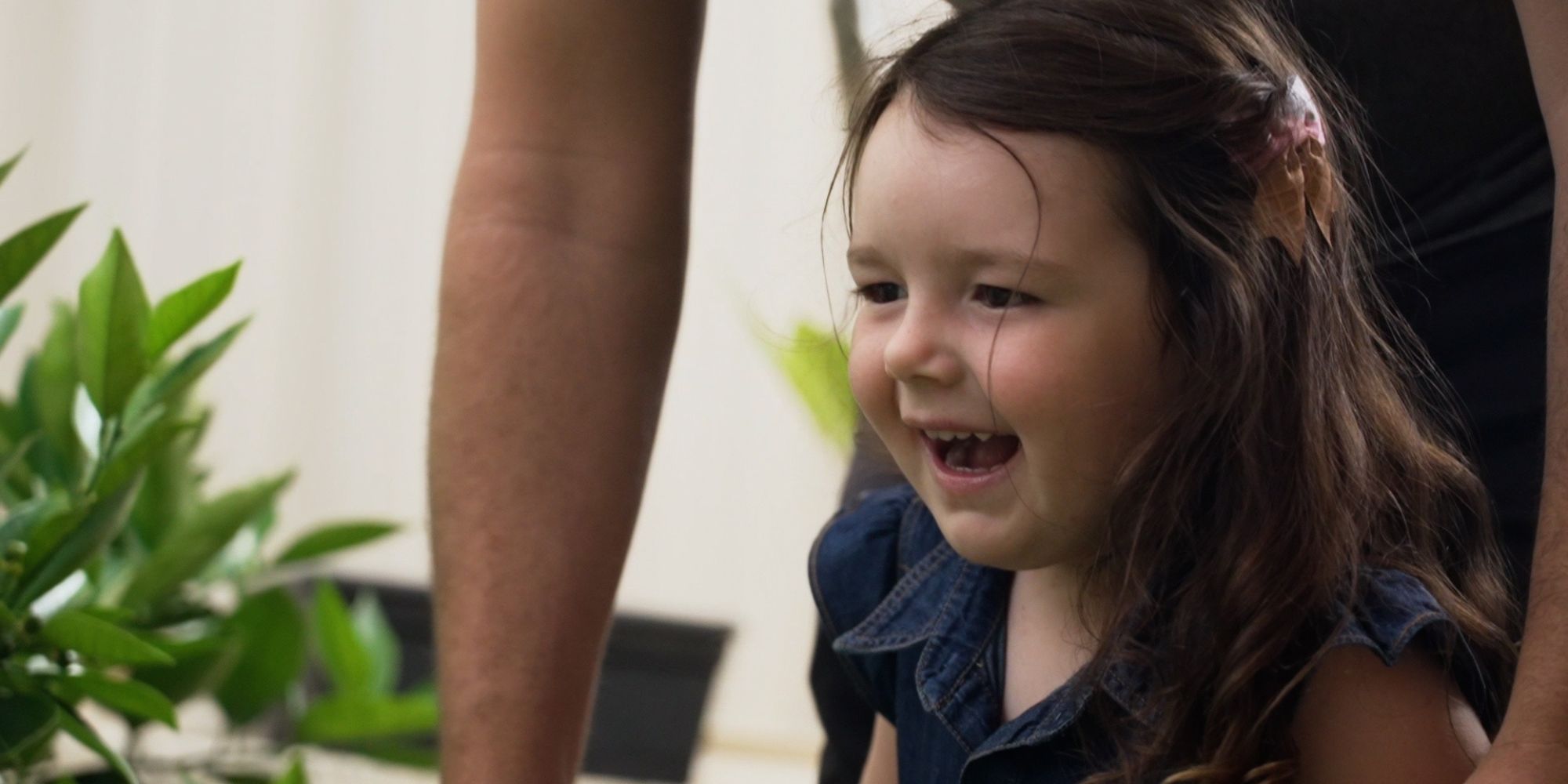 Early intervention explained. A three year old girl smiling.