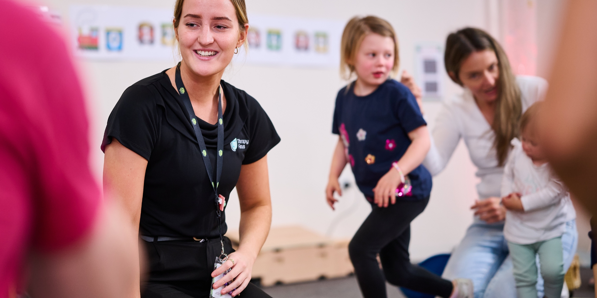 Term 4 First Focus: Early Intervention Program with Therapy Focus banner. The banner consists of an image of a Therapy Focus staff member with a child and her mother