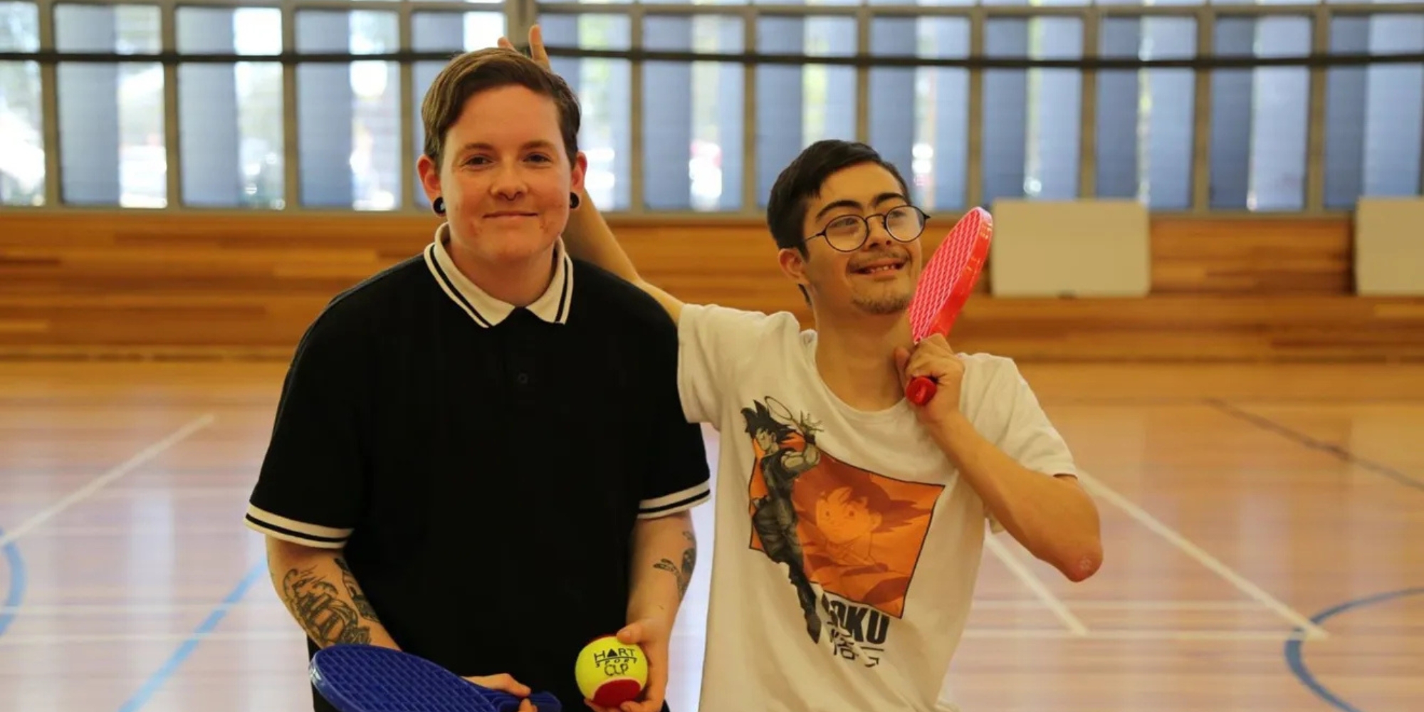 Fit 4 all Sports, Disco and Crafting with the City of Canning banner. The banner consists of an image of two boy in the middle of a indoor basketball court. They are holding paddle rackets and a ball. They are both smiling at the camera.