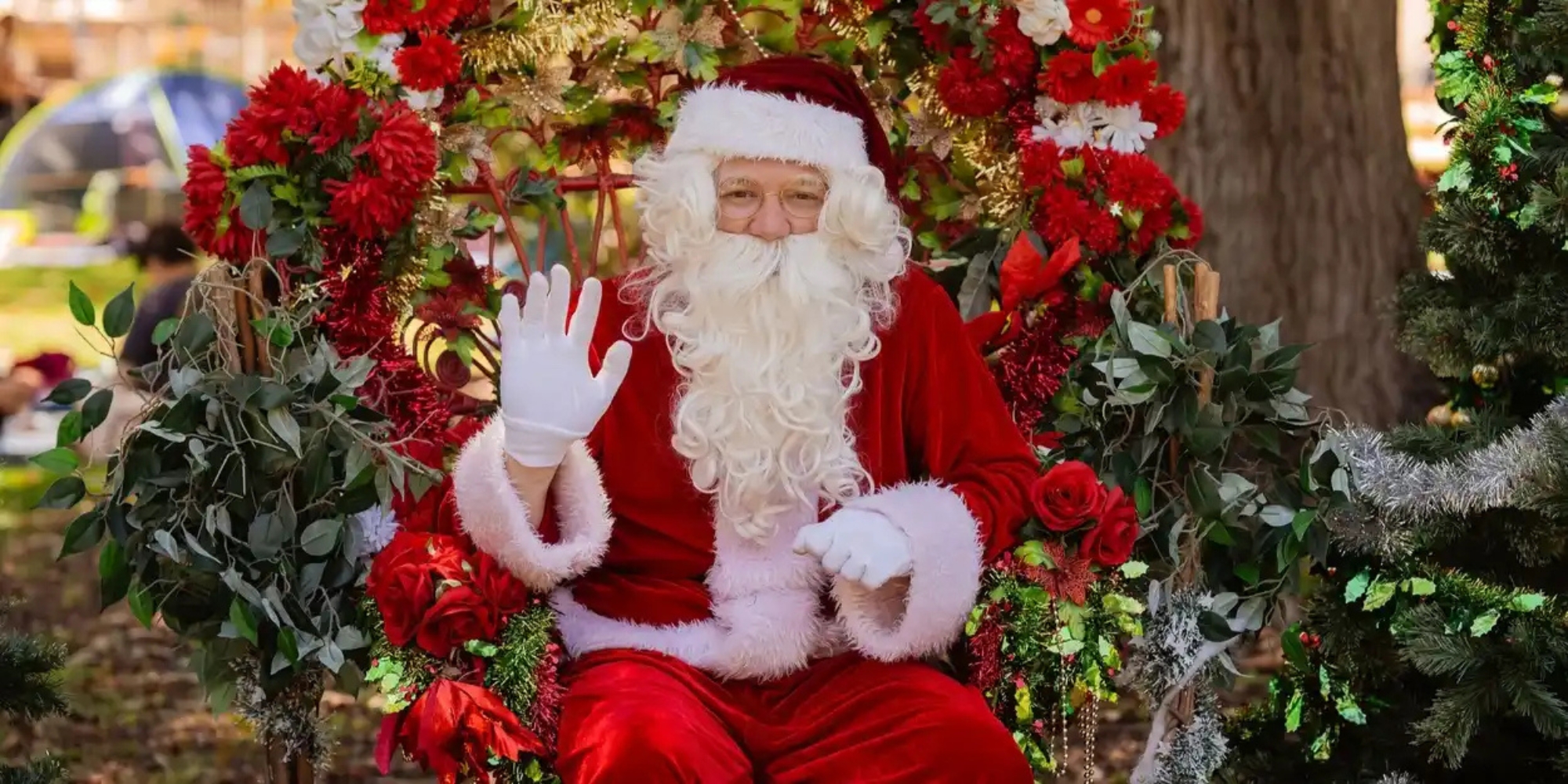 Variety WA Kids Christmas Party banner. The banner consists of an image of Santa clause sitting in a chair with Christmas decorations around him. He is waving at the camera.