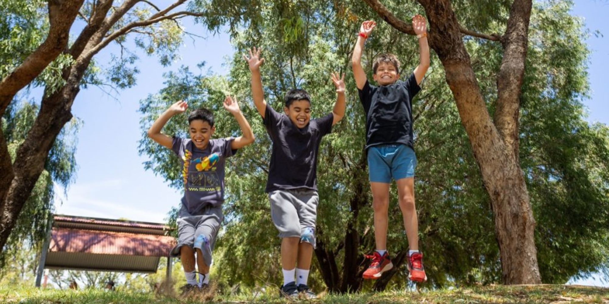 April Telethon Holiday Makers Program with Spectrum Space banner. The banner consists of an image of three children jumping with their hands in the air outdoors in the park.