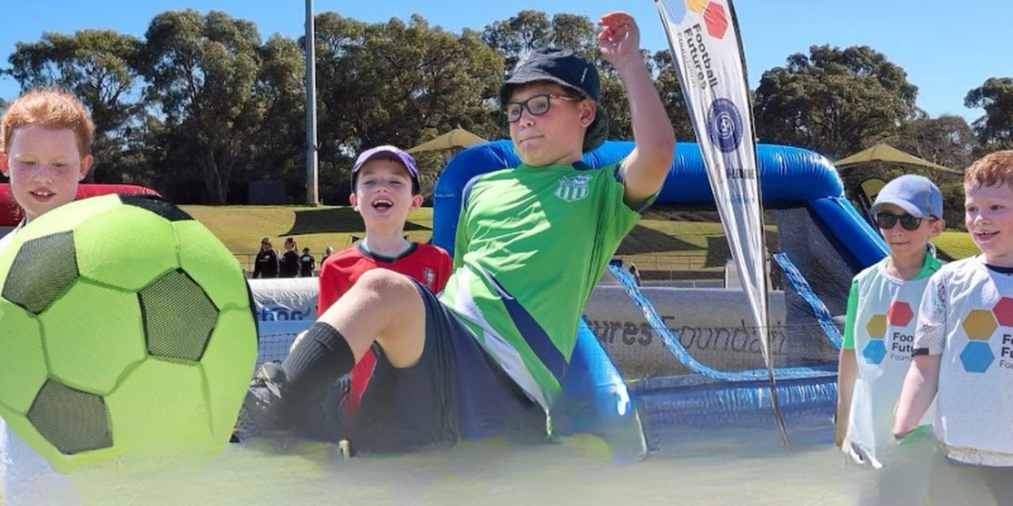 Inclusive soccer with Football Futures Foundation banner. The banner consists of an image of a group of boys playing soccer. The foreground of a boy kicking a green soccer ball.