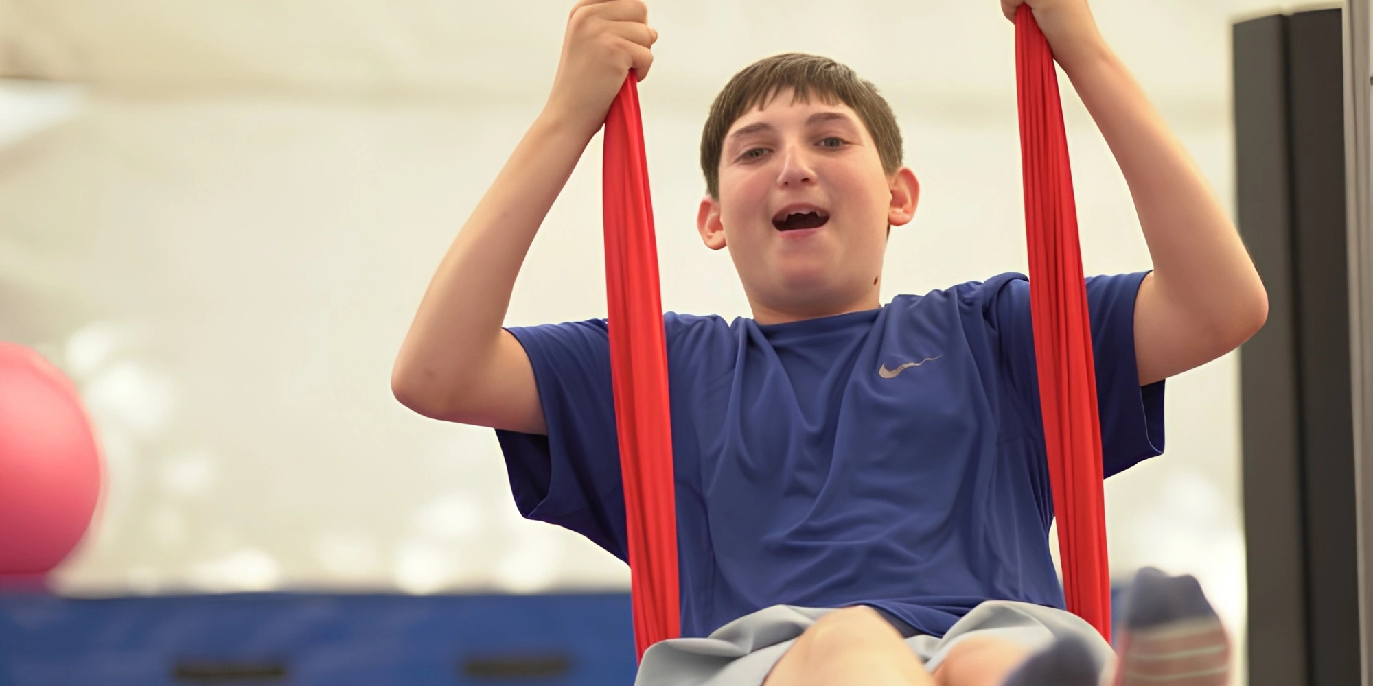 All Abilities Circus Program: Circus? You Can! with CircusWA banner. The banner consists of an image of a boy holding in to a acrobatic rope swing that is red and he is smiling at the camera.
