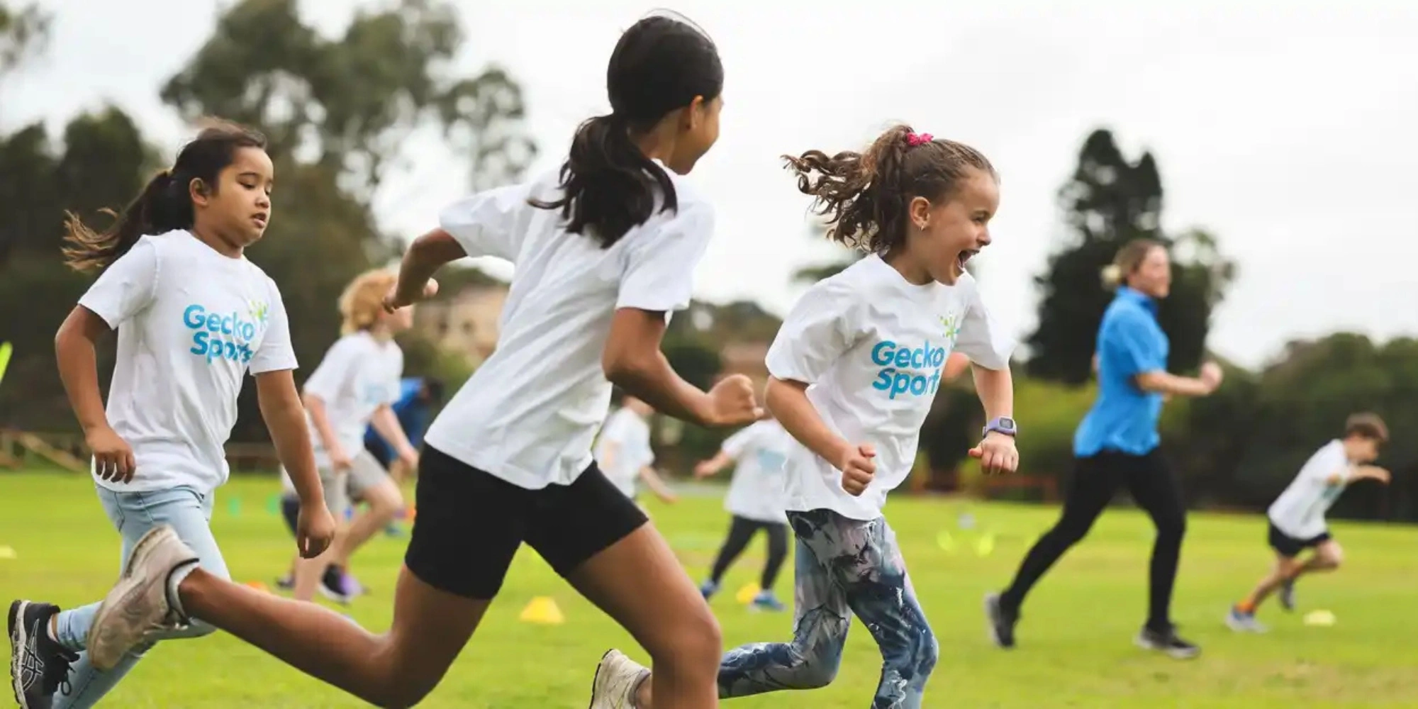 GeckoSports Amazing Race banner with the City of Belmont and GeckoSports. The banner consists of an image of children wearing a GeckoSports t-shirt while running in a field of grass.