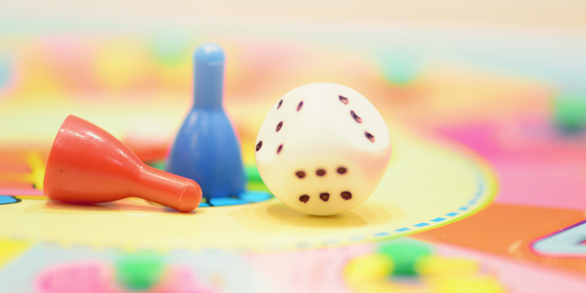 An image of a dice and game pieces on a game board.