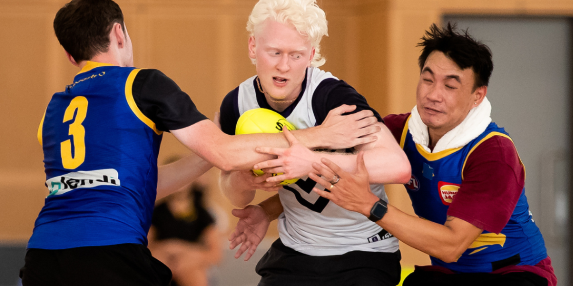 An image of three men playing football - Kiind's What's on activity and event guide