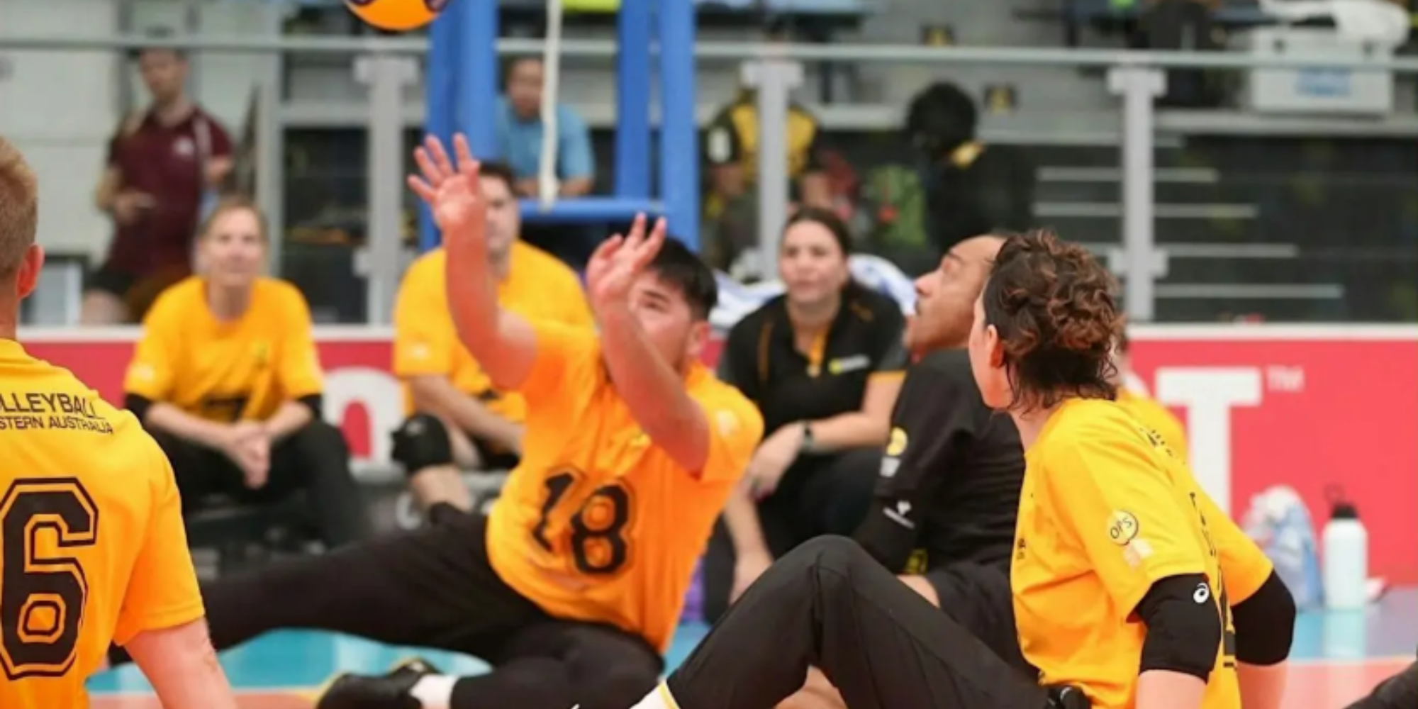 An image of a group of people playing sitting volleyball