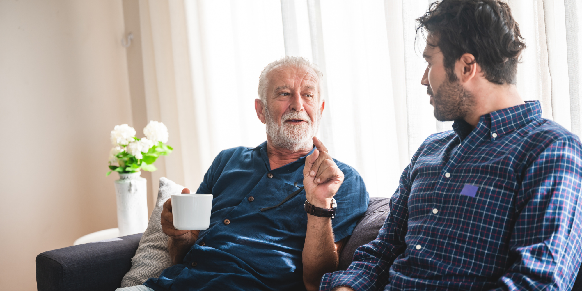 Two men engaged in conversation over coffee