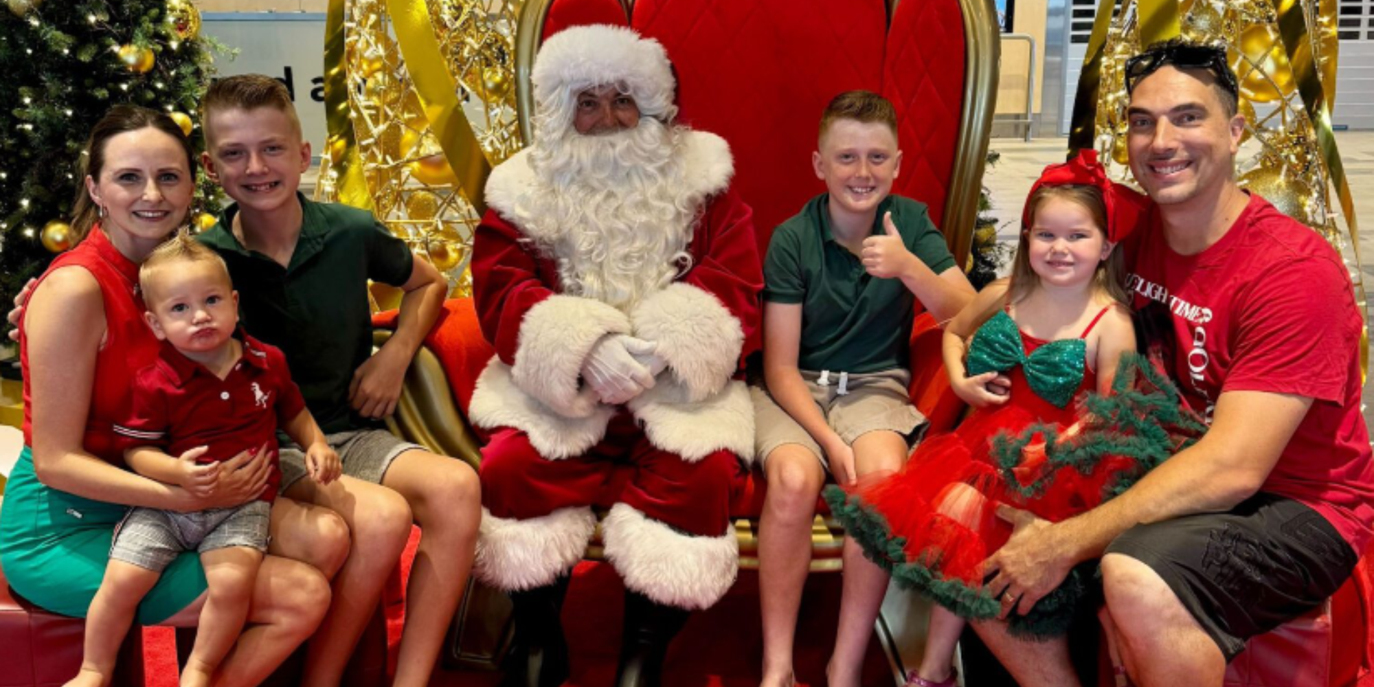 Santa posing in a photo with a family of four children and two parents