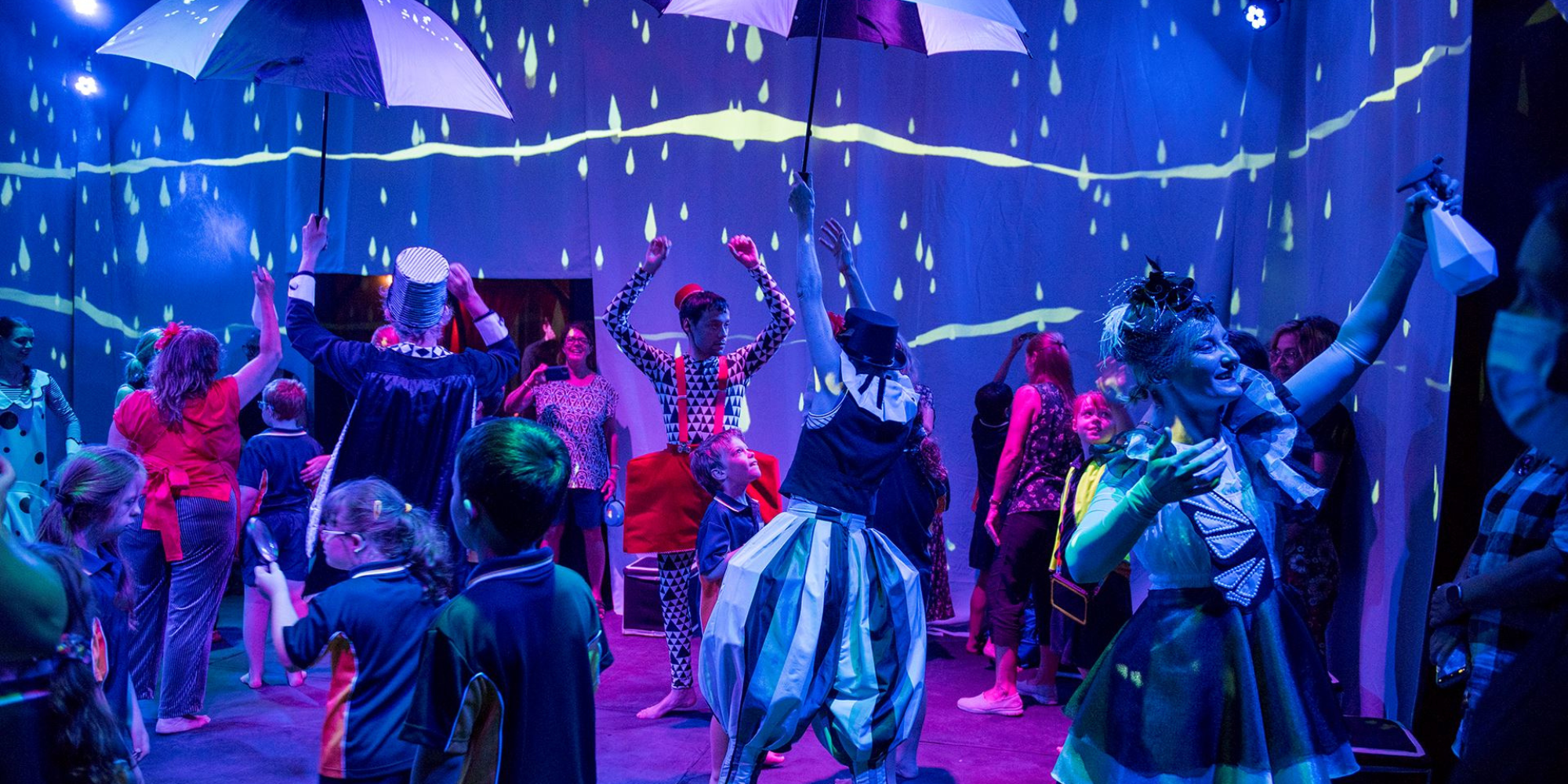 Wonderbox performers in costumes dancing with children in the audience