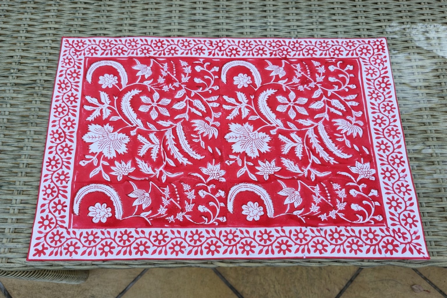Crimson Courtyard table mats in a layered place-setting layout