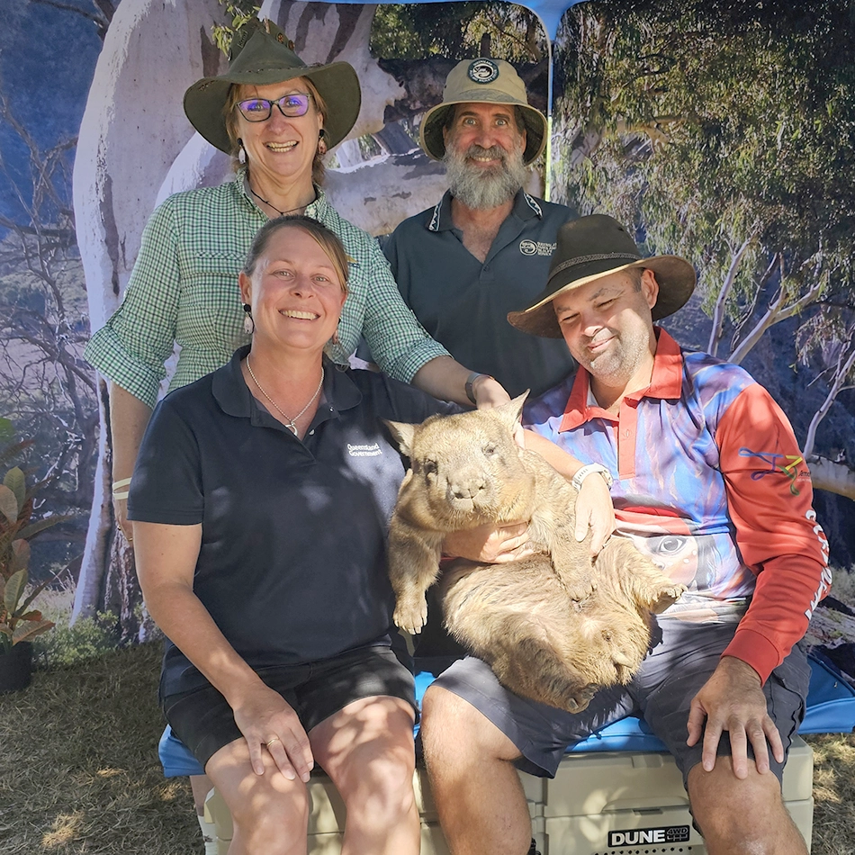 Four stakeholders in the Nurturing Northern hairy-nosed wombat project with a Southern hairy-nosed wombat during the wombat festival.