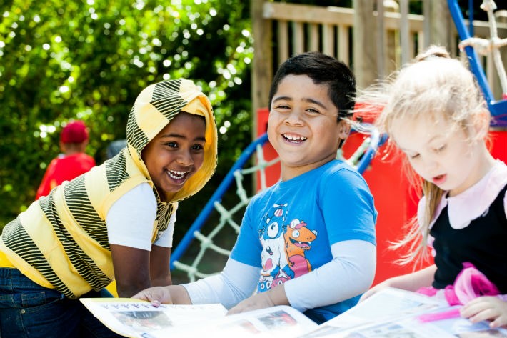 Photograph of smiling children sitting outside Photograph of smiling children sitting outside