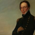 Full length oil portrait of a man dressed in navy colonial military uniform.