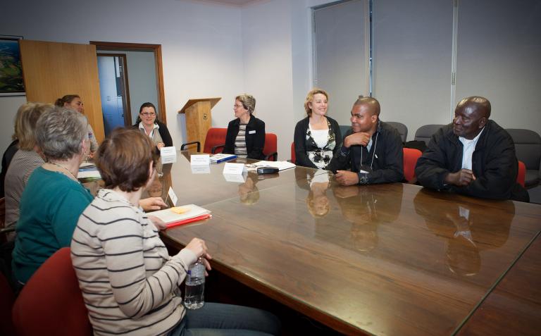 A group of people sit around a conference table.